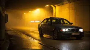 BMW Serie 3 avec message d'avertissement sous une lumière jaune inquiétante.