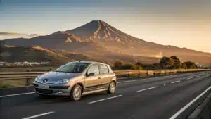 Une Peugeot 206 roulant sur une autoroute avec une montagne en arri&egrave;re-plan (symbolisant voyage et fiabilit&eacute;).